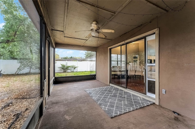 unfurnished sunroom with ceiling fan