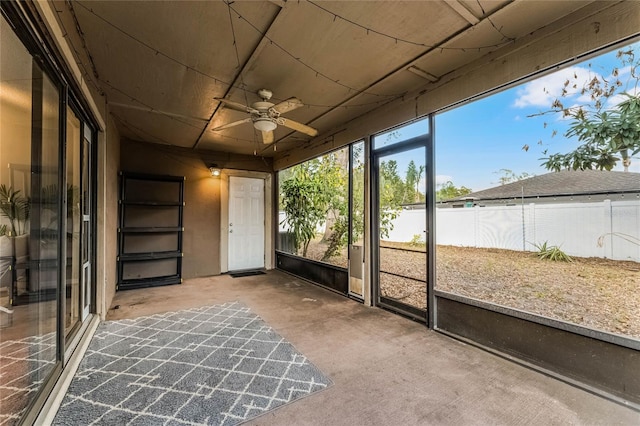 unfurnished sunroom featuring ceiling fan