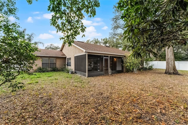 back of house featuring a sunroom and a lawn