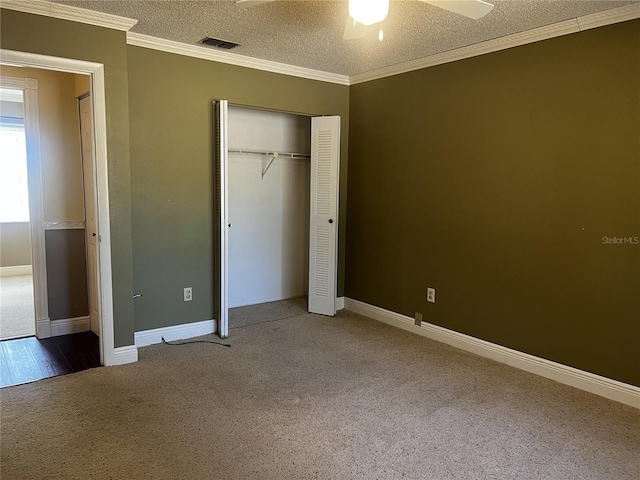 unfurnished bedroom featuring carpet floors, ornamental molding, a closet, and a textured ceiling