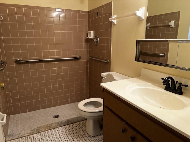 bathroom featuring vanity, tiled shower, tile patterned floors, and toilet