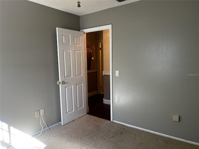 empty room featuring carpet floors and a textured ceiling