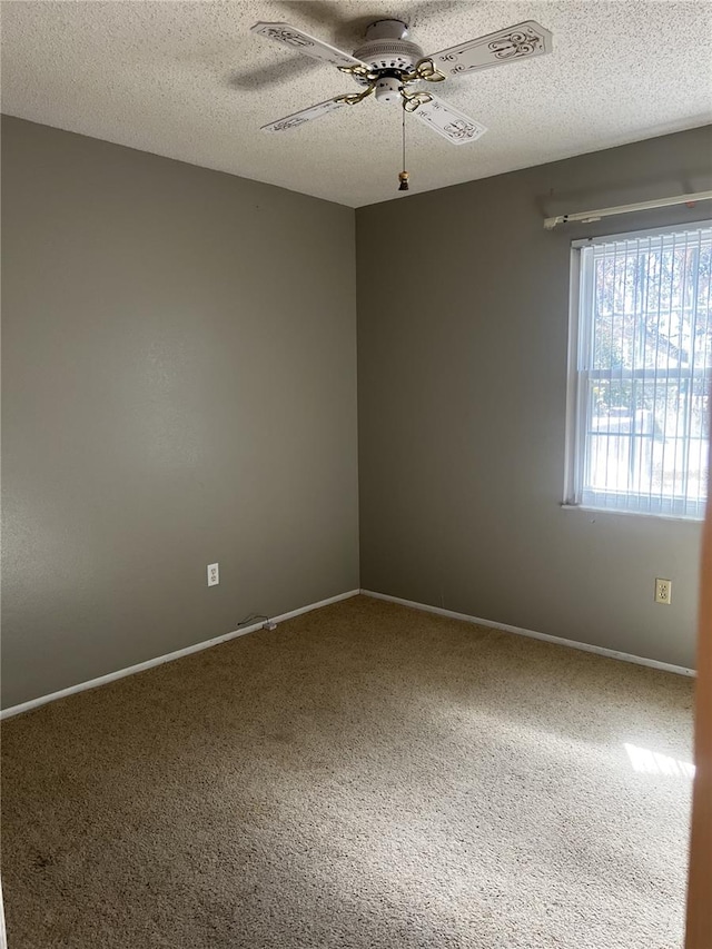 carpeted spare room featuring a textured ceiling and ceiling fan