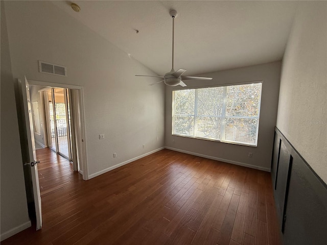 empty room with ceiling fan, a healthy amount of sunlight, dark hardwood / wood-style floors, and high vaulted ceiling