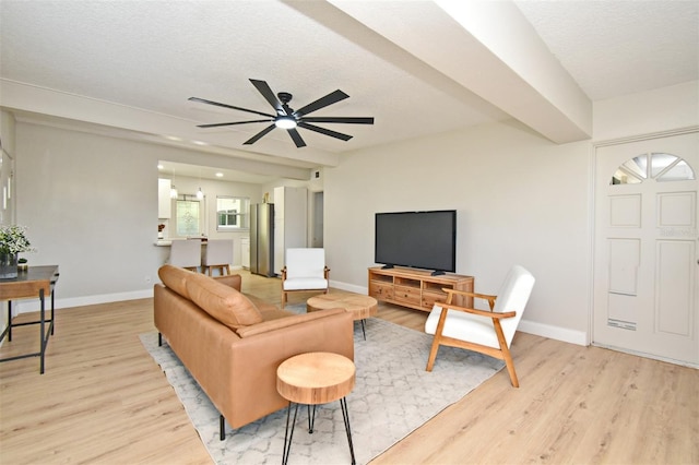 living room with a textured ceiling, light hardwood / wood-style flooring, and ceiling fan