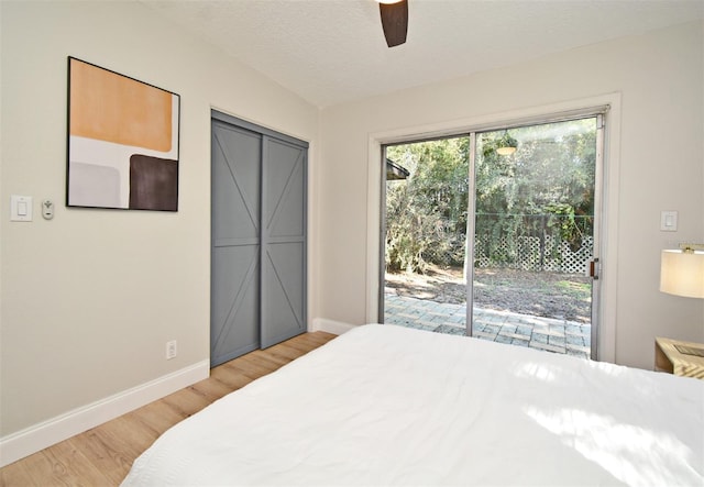 bedroom with light hardwood / wood-style flooring, ceiling fan, access to exterior, a textured ceiling, and a closet