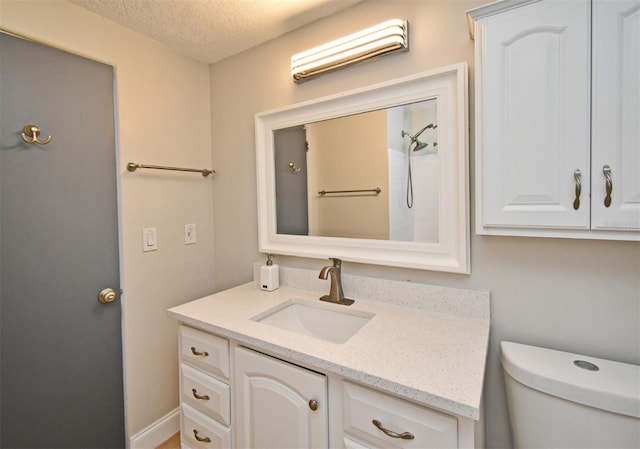 bathroom featuring vanity, toilet, and a textured ceiling