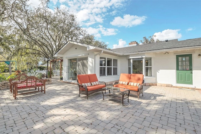 back of property with an outdoor living space and a patio