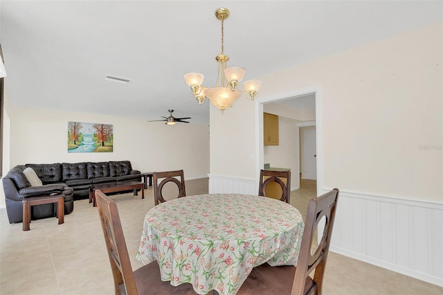 dining area featuring light tile patterned flooring and ceiling fan with notable chandelier