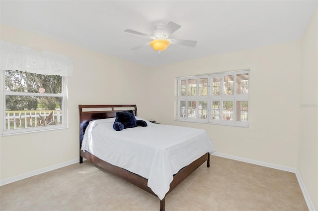 bedroom featuring multiple windows, light tile patterned floors, and ceiling fan