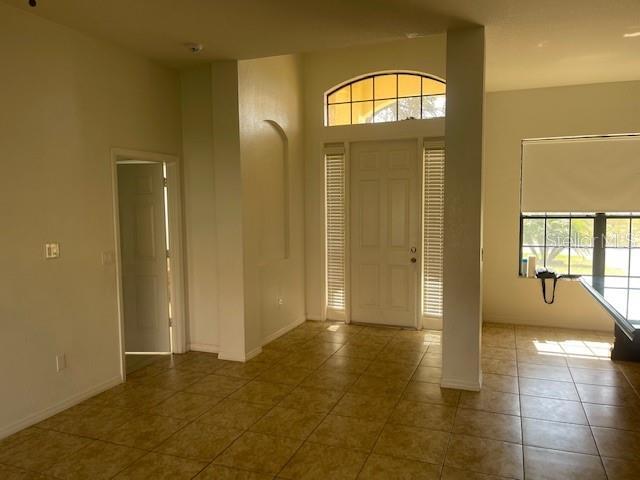 entrance foyer with a towering ceiling and tile patterned floors