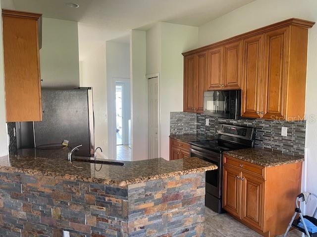 kitchen with sink, decorative backsplash, dark stone counters, and appliances with stainless steel finishes