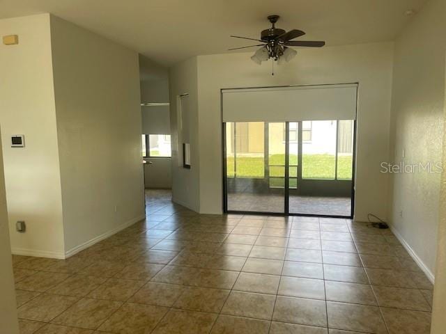 tiled empty room featuring ceiling fan