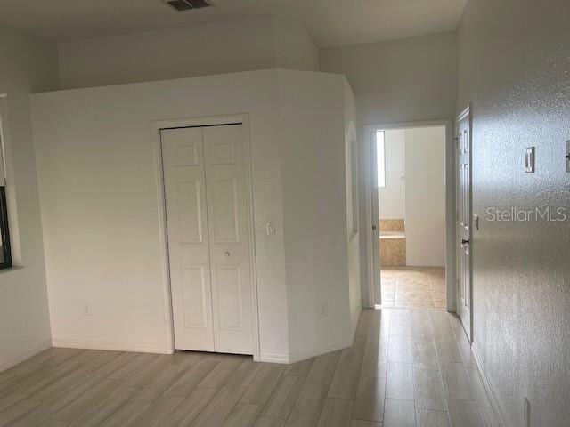 unfurnished bedroom with light hardwood / wood-style flooring and a closet