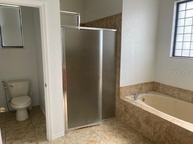 bathroom featuring tile patterned flooring, plus walk in shower, and toilet