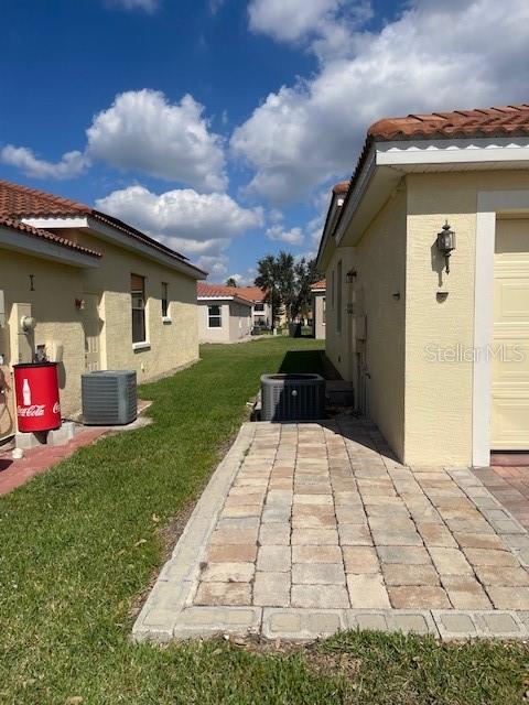 exterior space featuring central AC unit and a lawn