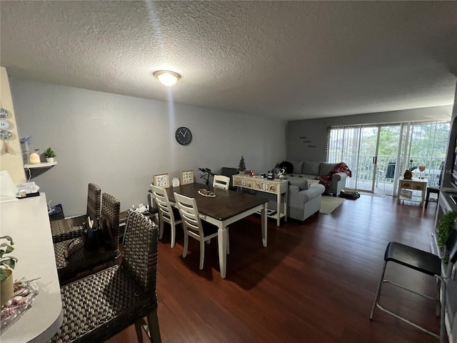 dining space with a textured ceiling and wood finished floors