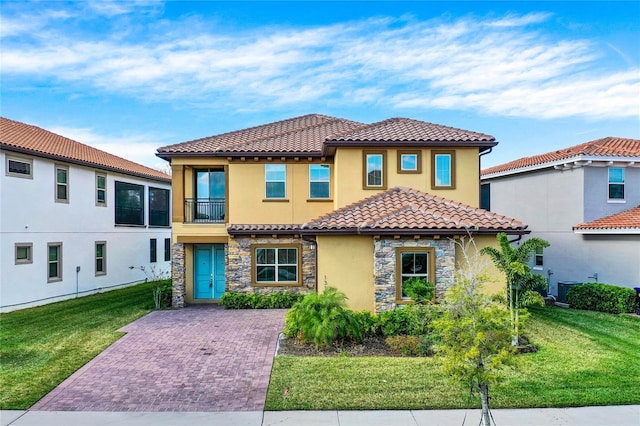 mediterranean / spanish house featuring a balcony and a front yard