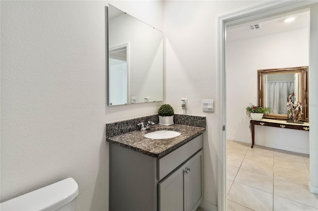 bathroom with vanity, toilet, and tile patterned flooring