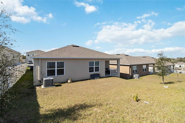 back of property featuring central AC unit and a lawn