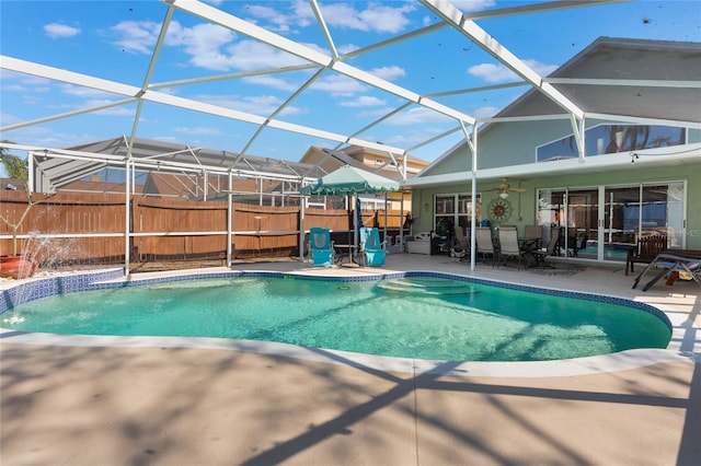 view of pool featuring a patio area, pool water feature, and glass enclosure