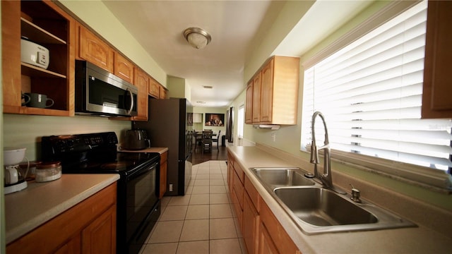 kitchen featuring stainless steel microwave, black electric range, open shelves, a sink, and light tile patterned flooring