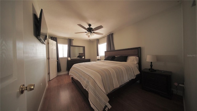 bedroom featuring dark wood-type flooring, ceiling fan, and baseboards