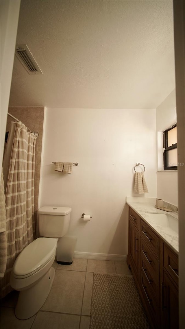 full bath featuring toilet, vanity, baseboards, visible vents, and tile patterned floors