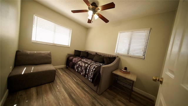 living area with ceiling fan, baseboards, and wood finished floors