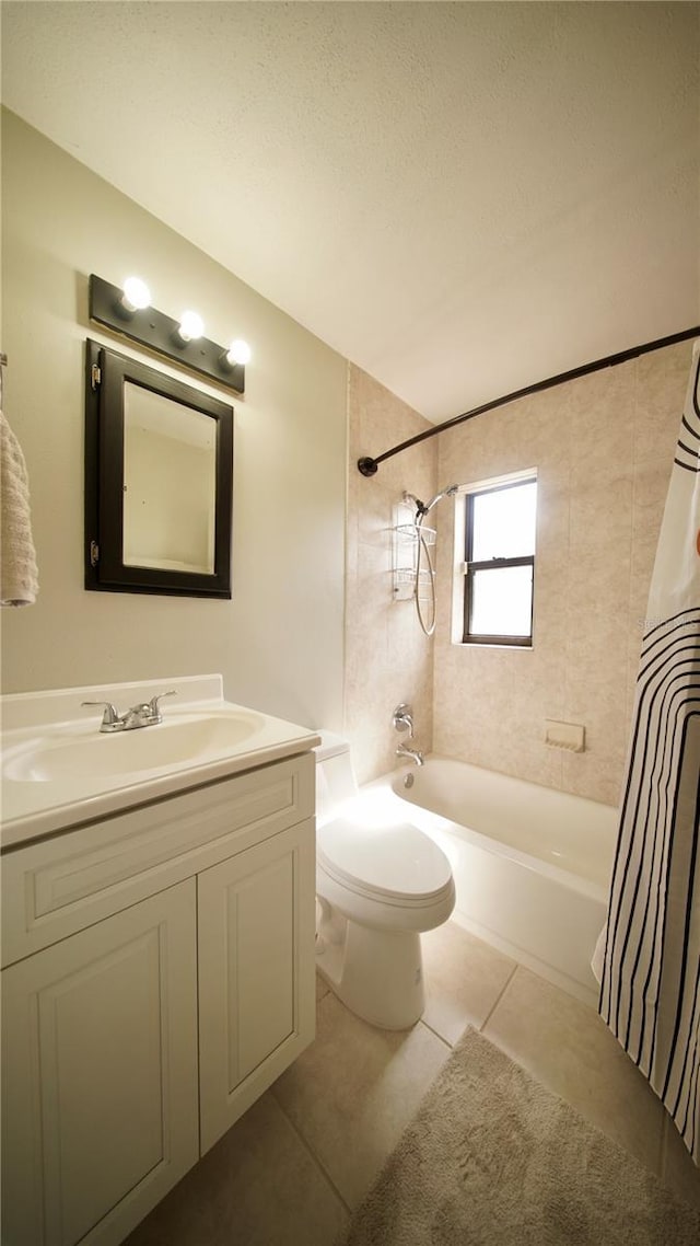 bathroom with a textured ceiling, tile patterned flooring, toilet, vanity, and shower / bath combo