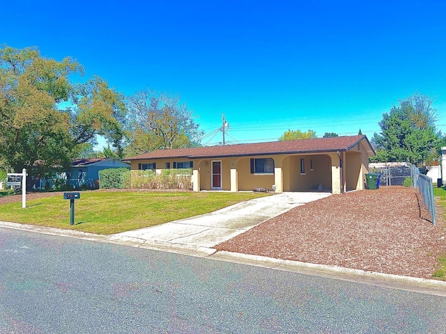 single story home with concrete driveway, an attached carport, fence, a front lawn, and stucco siding