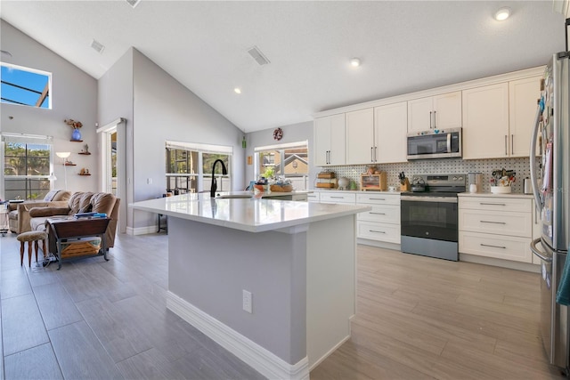 kitchen with stainless steel appliances, light countertops, a sink, and visible vents