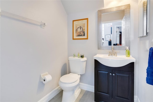 bathroom with vanity, toilet, and baseboards