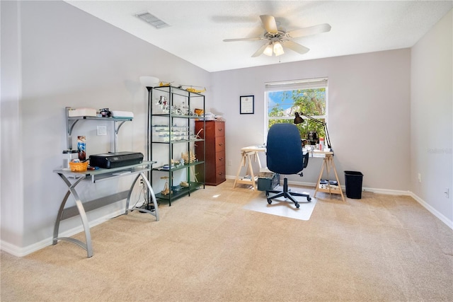 carpeted office space featuring baseboards, visible vents, and a ceiling fan