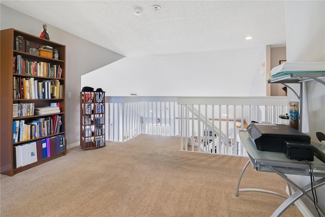 sitting room with carpet, baseboards, and a textured ceiling