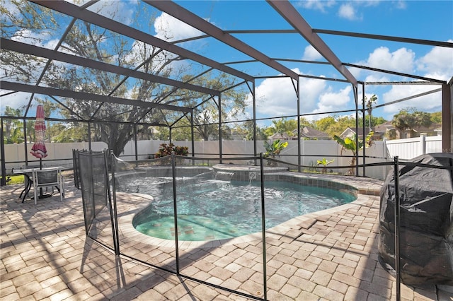 view of swimming pool featuring a lanai, a fenced backyard, and a patio