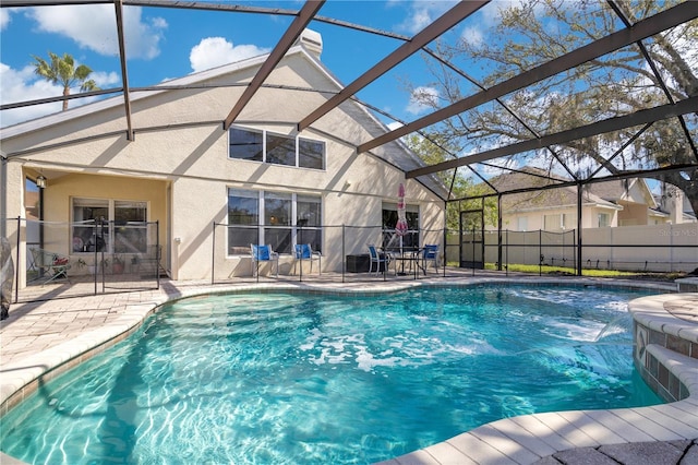 view of pool featuring a patio, glass enclosure, fence, and a fenced in pool