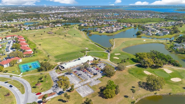 birds eye view of property with view of golf course and a water view