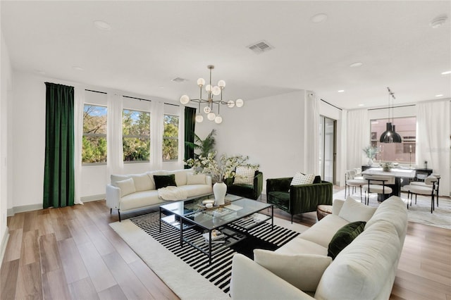 living room with a chandelier and light wood-type flooring