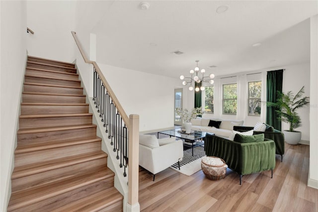 living room with a chandelier and light wood-type flooring