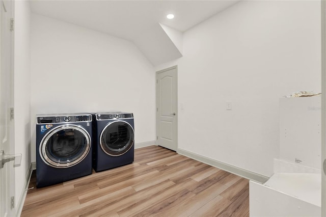 washroom with washer and clothes dryer and light wood-type flooring