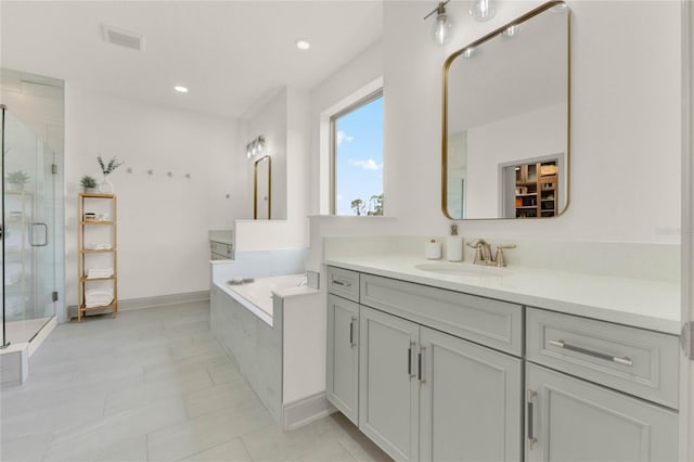 bathroom featuring vanity, tile patterned flooring, and shower with separate bathtub