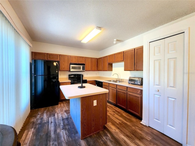 kitchen with a center island, sink, dark hardwood / wood-style flooring, and black appliances