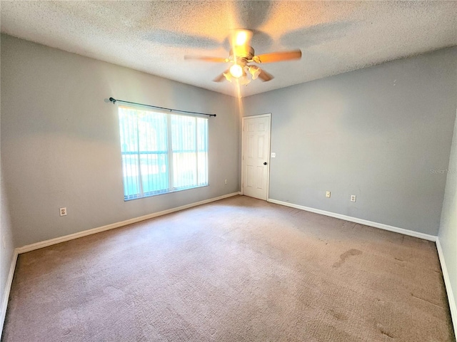 empty room featuring a textured ceiling, carpet floors, and ceiling fan