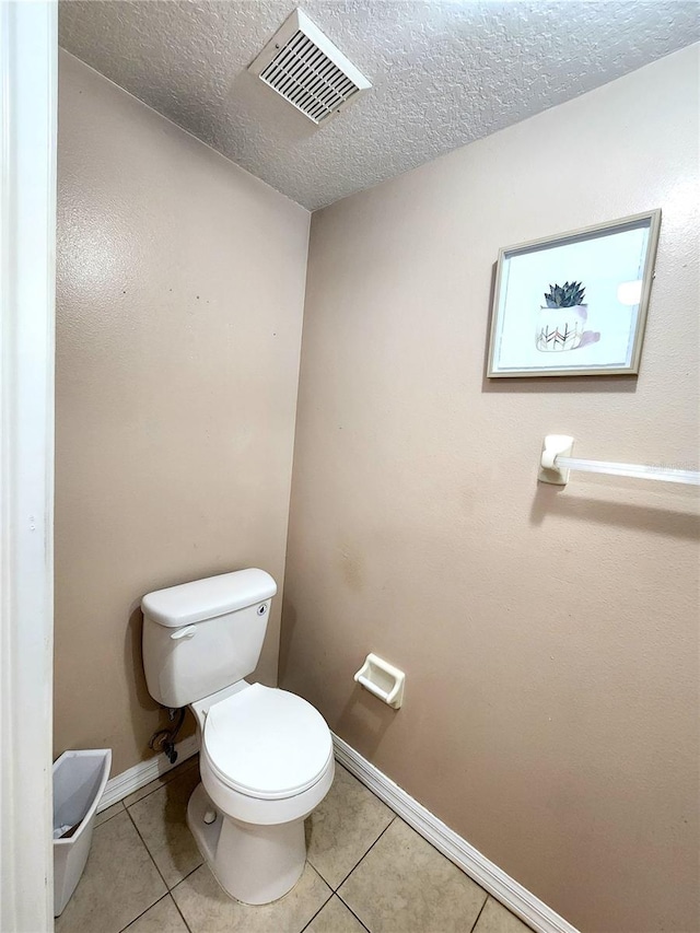 bathroom featuring tile patterned flooring, a textured ceiling, and toilet