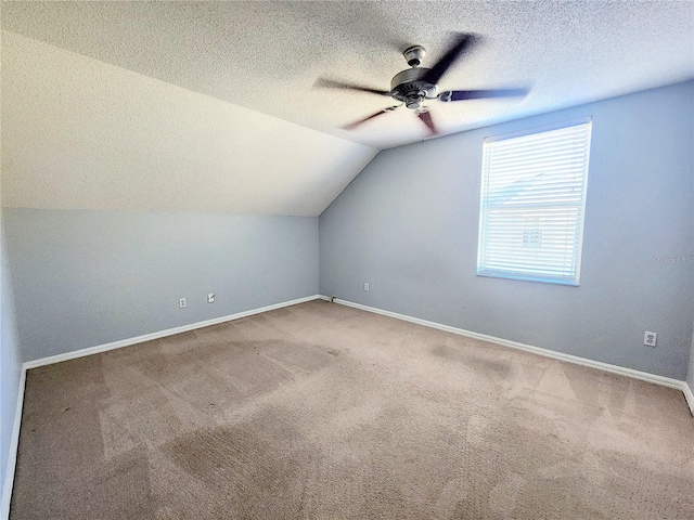 bonus room with light carpet, vaulted ceiling, and a textured ceiling