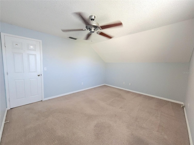 bonus room featuring vaulted ceiling, light carpet, ceiling fan, and a textured ceiling