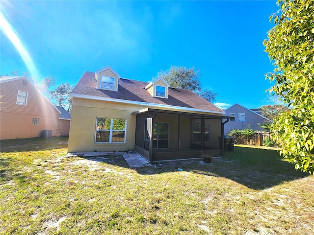 back of property featuring a yard and a sunroom