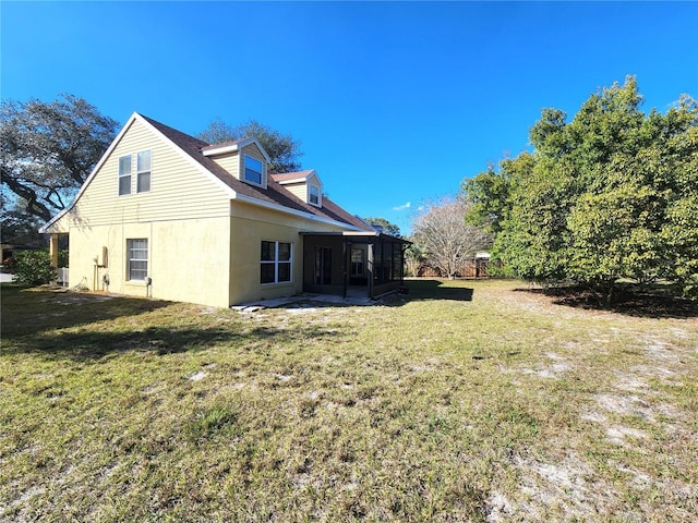 back of house with a lawn and a sunroom