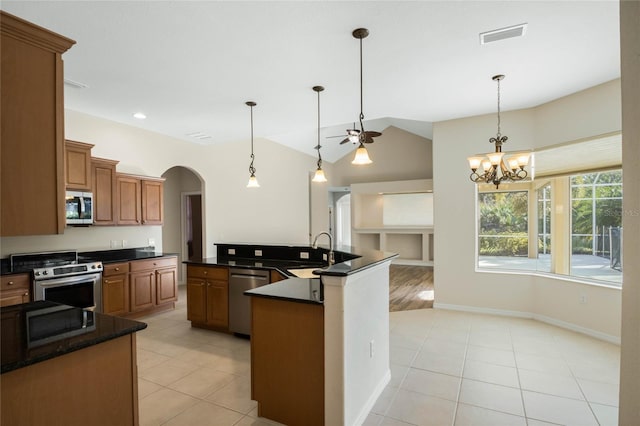 kitchen featuring appliances with stainless steel finishes, ceiling fan with notable chandelier, an island with sink, sink, and hanging light fixtures